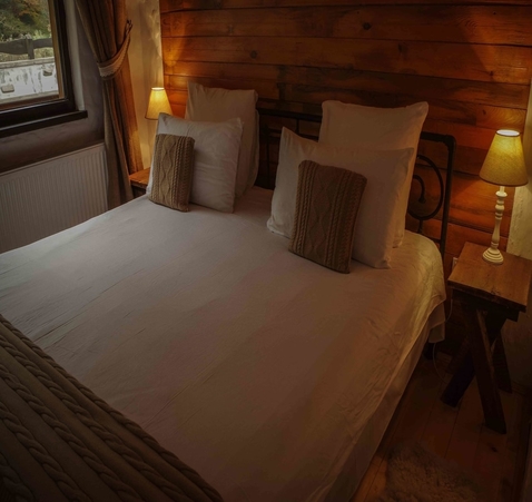 Cozy bed with pillows and rustic decor at Biovaleputna guest house